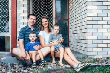 Young family sitting on front porch